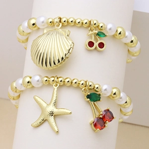 Golden bead and pearl bracelet set featuring cherry, starfish, and seashell charms