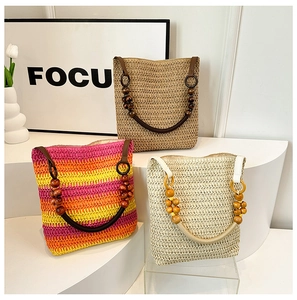 Three straw shoulder bags with woven texture, wooden bead handles in varied colors