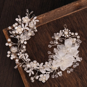Detailed shot of bridal hair comb with pearls, rhinestones and white silk flowers