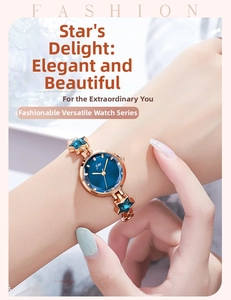 Detail of rose gold starfish charms and blue dial watch worn on a female wrist