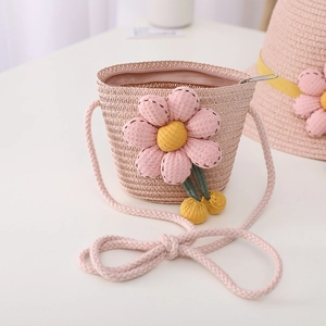 Detailed view of pink straw crossbody bag with 3D floral accents and metal zipper