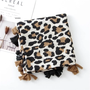 Detailed view of leopard print scarf with two-tone tassels and elegant soft texture
