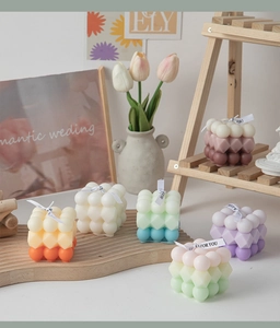 Macro shot of colorful bubble cube scented candles with silk ribbons on wooden decor
