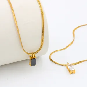 Macro detail of square zircon and black agate pendants on gold plated snake chains