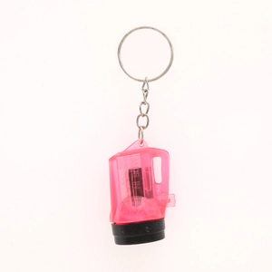 Close-up of pink translucent flashlight keychain with silver metal ring and chain