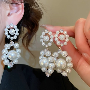 Vue détaillée de boucles d'oreilles double anneau avec perles blanches et zircons brillants