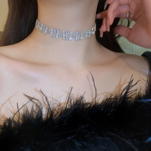 Silver square pendant necklace with sparkling rhinestones worn by a model in black feathers