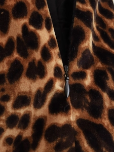 Detailed close-up of leopard print velvet fabric with a black zipper detail