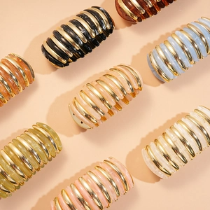Detail of bird nest hair clips with marbled resin inserts and metallic gold frame