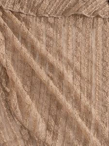 Gros plan sur un tissu en maille crochetée beige avec broderie florale pour la plage