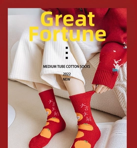 Détail de chaussettes festives en polaire corail rouge avec motif orange tricoté