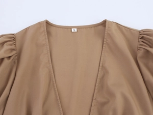 Detail of elegant V-neckline and puff sleeve pleats on brown vintage style dress