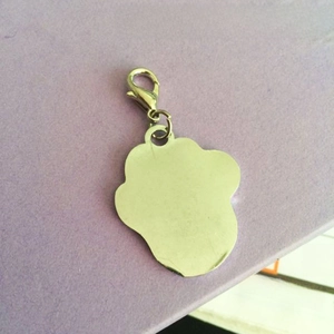 Detailed close-up of zinc alloy pet ID tag back with lobster clasp on a purple background
