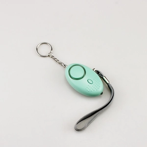 Detail view of a light green personal safety alarm with keychain and grey wrist strap