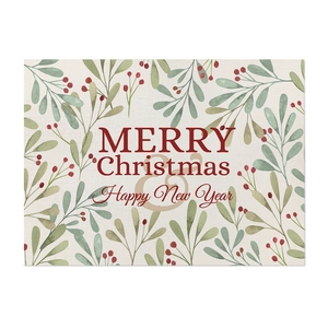 Close-up of linen placemat featuring Merry Christmas print and festive plant berries