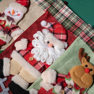 Trois chaussettes de Noël à carreaux avec figurines du Père Noël, bonhomme de neige et renne