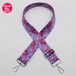 Detail of adjustable Bohemian wide strap with geometric patterns and silver hardware