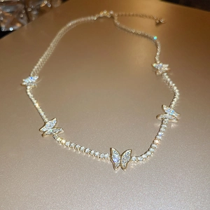 Detailed close-up of golden butterfly necklace with sparkling zircon crystal stones