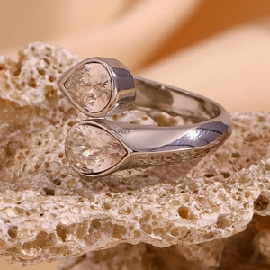 Macro shot of 18K plated open ring with double pear-cut zircon on coral stone base