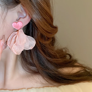 Detail showing pink heart earrings with layered mesh fabric petals on a female model