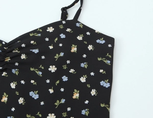 Detail of floral dress neckline with thin adjustable straps and ruffled chest design