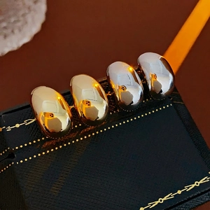 Polished gold and silver bean-shaped C-style stud earrings on premium navy box