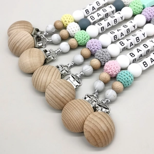 Close-up of colorful baby pacifier clips made of beech wood, silicone, and crochet beads