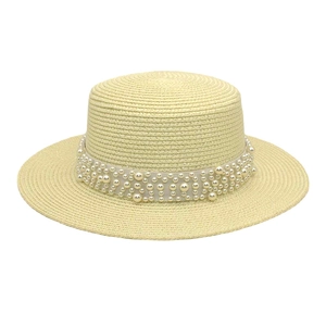 Détail d'un chapeau de paille à haut plat avec élégante bande de perles pour femmes