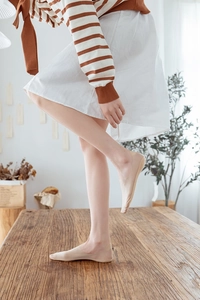 Close-up of nude invisible low-cut socks worn by model in a soft indoor setting