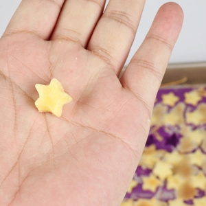 Macro shot of a small yellow star-shaped silicone candy mold held in a palm for scale