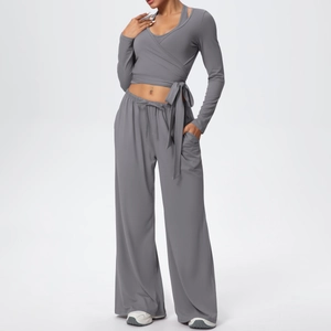 Détail d'un ensemble de yoga gris avec haut croisé à manches longues et pantalon large
