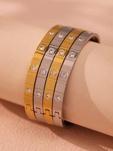 Macro view of segmented 18K gold plated stainless steel bangles with sparkling 5A crystals