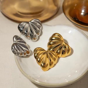 Boucles d'oreilles cœur bombé dorées et argentées avec texture côtelée sur assiette