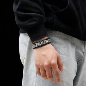 Men's punk braided black leather and silver stainless steel wide chain bracelet on wrist