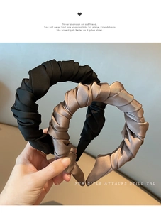 Detail of wide pleated satin headbands in black and champagne gold with silk texture