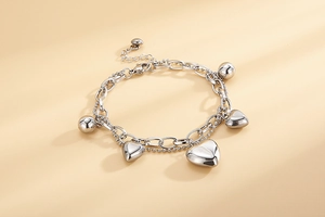 Détail d'un bracelet double couche argenté avec pendentifs cœurs et perles polies