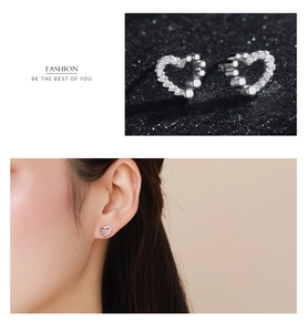 Macro detail of asymmetrical 925 silver heart stud earrings with cubic zirconia stones