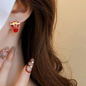 Detail of red and white lion dance stud earrings with bead pendant on model's ear
