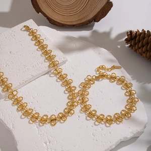 Detailed shot of golden interlocking chain necklace on white stone with rustic decor