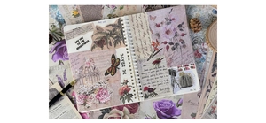 Flat lay of vintage scrapbooking material with floral butterfly art and aged paper textures
