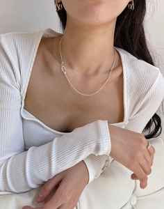 Minimalist 925 sterling silver chain necklace styled on a model with white knitwear