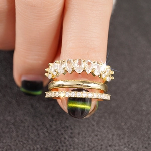 Dettaglio del set di anelli dorati con zircone ovale e cristalli pavé scintillanti