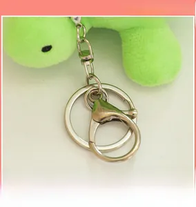 Detail of the silver metal lobster clasp and keychain ring on the green plush turtle toy