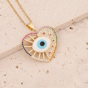 Macro detail of heart-shaped evil eye pendant with colorful CZ stones and enamel