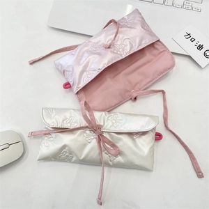 Vue détaillée de pochettes en satin matelassé avec broderie nœud et ruban à nouer