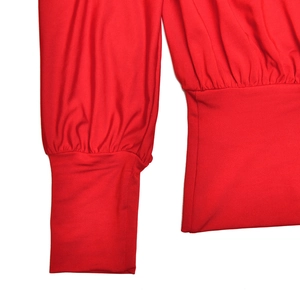 Detail view of red slim-fit top featuring ribbed knit cuffs and waist pleat design