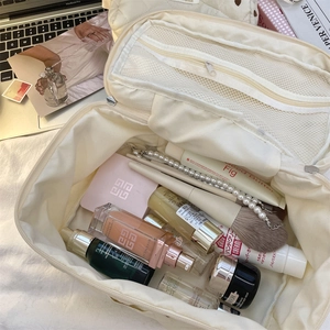 Top view of cream quilted heart makeup bag showing large capacity for cosmetics