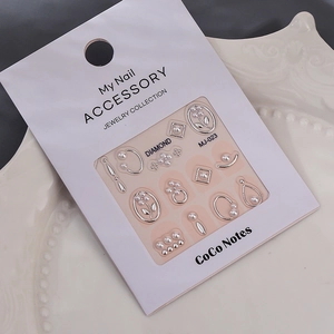 Macro detail of silver floral nail accessories with pearls on MJ-023 retail card