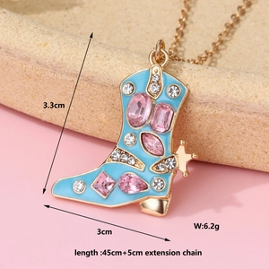 Dettaglio del ciondolo a stivale in smalto blu con strass rosa su catena d'oro
