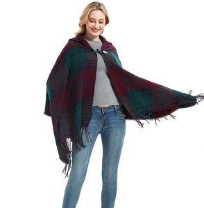 Detail view of red and green plaid poncho featuring a hood, toggle button and tassel hem